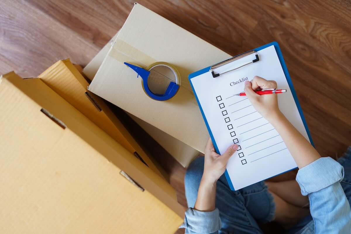 Professional movers carefully packing household items into labeled moving boxes